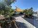 Charming home featuring a lush front yard with mature trees, desert landscaping and an inviting shade sail at 1819 Beverly Way, Las Vegas, NV 89104