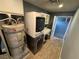 Functional laundry room featuring a stacked washer and dryer, water heater, storage cabinets, and countertop at 1819 Beverly Way, Las Vegas, NV 89104