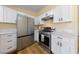 Well-equipped kitchen featuring white cabinets, stainless steel appliances, and quartz countertops at 1828 Golden Arrow Dr, Las Vegas, NV 89169