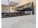 Close-up of a modern gas range on a quartz countertop, with white cabinets at 1828 Golden Arrow Dr, Las Vegas, NV 89169