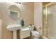 Elegant bathroom with a pedestal sink, tiled shower, and neutral color scheme at 2090 Eaglepath Cir, Henderson, NV 89074