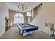 Open game room features a pool table, chandelier, and arched window at 2090 Eaglepath Cir, Henderson, NV 89074