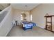 Spacious carpeted living room featuring a staircase, chandelier, and a pool table for entertainment at 2090 Eaglepath Cir, Henderson, NV 89074