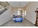 Spacious carpeted living room featuring a staircase, chandelier, and a pool table for entertainment at 2090 Eaglepath Cir, Henderson, NV 89074