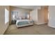 Cozy main bedroom featuring plush carpet, ensuite bathroom entrance and ample natural light from large window at 2090 Eaglepath Cir, Henderson, NV 89074
