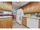 Functional kitchen with wood cabinetry, white appliances, and tile flooring at 22 Jade Cir, Las Vegas, NV 89106