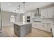 Well-lit kitchen featuring a gray island, stainless steel appliances, and stylish light fixtures at 2603 Savannah Springs Ave, Henderson, NV 89052