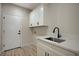 Modern laundry room with white cabinets, countertops, and black hardware at 2603 Savannah Springs Ave, Henderson, NV 89052