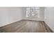 Empty bedroom featuring wood-look floors, a large window, and natural light creating a bright open space at 270 Snowy River Cir, Henderson, NV 89074