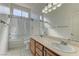 Bathroom with double vanity sinks, shower over tub, and neutral tile at 2725 Cool Lilac Ave, Henderson, NV 89052