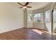 Bright bedroom with wood floors features a ceiling fan, large windows, and a mirrored closet at 2725 Cool Lilac Ave, Henderson, NV 89052