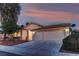 Attractive single-story home featuring a two-car garage, desert landscaping, and a tile roof at twilight at 2725 Cool Lilac Ave, Henderson, NV 89052