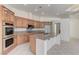 Updated kitchen showcases wooden cabinets, granite countertops, stainless steel appliances, and center island at 2725 Cool Lilac Ave, Henderson, NV 89052