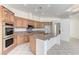 Well-appointed kitchen featuring an island with a sink and seating, tile floors, and wooden cabinets at 2725 Cool Lilac Ave, Henderson, NV 89052