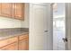 Kitchen area with wood cabinets, granite countertops, access door and view into an adjacent room at 2725 Cool Lilac Ave, Henderson, NV 89052