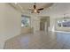 Bright living room boasts neutral walls, tile flooring, ceiling fan and ample natural light through large windows at 2725 Cool Lilac Ave, Henderson, NV 89052