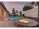 Resort-style backyard featuring a sparkling pool and adjacent hot tub surrounded by mature landscaping at 2725 Cool Lilac Ave, Henderson, NV 89052
