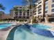 Relaxing in-ground pool with a blue-tiled spa, palm trees, and surrounding condo buildings at 29 Montelago Blvd # 336, Henderson, NV 89011