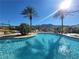 Community pool surrounded by palm trees and mountains provides a relaxing desert oasis at 29 Montelago Blvd # 336, Henderson, NV 89011