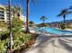 Beautiful community pool featuring multiple palm trees, lounge chairs, and clear blue water at 29 Montelago Blvd # 336, Henderson, NV 89011