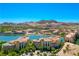 Stunning aerial view of a lakeside community with mountain backdrop and meticulously designed buildings under a clear blue sky at 29 Montelago Blvd # 520, Henderson, NV 89011