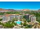 Stunning aerial view of the luxury condominium complex surrounded by lush landscaping and a pool with a mountain backdrop at 29 Montelago Blvd # 520, Henderson, NV 89011