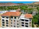 Exterior view of luxury condos with red tile roof and meticulously designed balconies overlooking lush golf course and hills at 29 Montelago Blvd # 520, Henderson, NV 89011