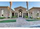 Elegant clubhouse entrance featuring a decorative gate, mature palm trees, and manicured landscaping at 2900 Sunridge Heights Pkwy # 518, Henderson, NV 89052