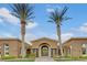 Elegant clubhouse entrance featuring a decorative gate, mature palm trees, and manicured landscaping at 2900 Sunridge Heights Pkwy # 518, Henderson, NV 89052