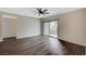 This empty living room boasts gray hardwood floors, a ceiling fan, and sliding glass doors leading to the outside at 2900 Sunridge Heights Pkwy # 518, Henderson, NV 89052
