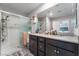 A bathroom featuring a double vanity with dark wood cabinetry and a sleek glass-enclosed shower at 2935 Saltillo Ln, Las Vegas, NV 89121