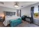 Bright bedroom featuring a plush, tufted headboard, stylish bench, and a ceiling fan at 2935 Saltillo Ln, Las Vegas, NV 89121