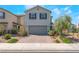 Charming two-story home with a brick driveway, gray exterior, and manicured landscaping at 2935 Saltillo Ln, Las Vegas, NV 89121