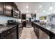 Modern kitchen features dark cabinetry, stainless steel appliances, granite countertops, and tiled flooring at 2935 Saltillo Ln, Las Vegas, NV 89121