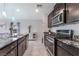 Beautiful kitchen showcasing dark cabinets, stainless steel appliances, granite counters, and stylish pendant lights at 2935 Saltillo Ln, Las Vegas, NV 89121
