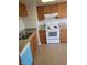 Updated kitchen featuring wood cabinets, tile countertops, stainless steel sink and a white oven appliance at 2981 Country Manor Ln # 118, Las Vegas, NV 89115