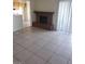 Open-concept living room with a brick fireplace, tile flooring, and sliding glass door leading to a patio at 2981 Country Manor Ln # 118, Las Vegas, NV 89115
