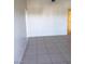 The Living room in this home has grey tile floors and white walls, with an open doorway into another room at 2981 Country Manor Ln # 118, Las Vegas, NV 89115
