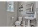 Cozy half-bathroom with pedestal sink, toilet, and floating shelves at 3132 Cartanda Ave, Henderson, NV 89044
