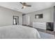 Relaxing main bedroom featuring a ceiling fan, large mirror, dresser, and mini-refrigerator at 3132 Cartanda Ave, Henderson, NV 89044