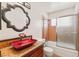 Bathroom featuring a red glass vessel sink, decorative mirror and tiled shower at 3250 Duneville St, Las Vegas, NV 89146