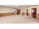Large living room with hardwood trim, multiple doors and neutral carpet at 3250 Duneville St, Las Vegas, NV 89146