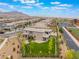 This aerial view shows the back of the home with a luscious, turfed back yard in a neighborhood near the mountains at 438 Wind Poppy St, Las Vegas, NV 89138