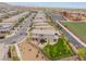 This aerial shows a back view of the home with an artificial turf backyard and nearby school with soccer fields at 438 Wind Poppy St, Las Vegas, NV 89138
