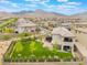 Spacious backyard with manicured lawn, young trees, trampoline, swing set, and mountain views at 438 Wind Poppy St, Las Vegas, NV 89138