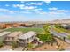 An aerial view of the two-story home featuring an artificial turf backyard and a school with soccer fields nearby at 438 Wind Poppy St, Las Vegas, NV 89138
