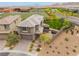 A two-story house with a desert landscape, artificial turf backyard, and a nearby school with soccer fields at 438 Wind Poppy St, Las Vegas, NV 89138