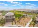 This two-story home features desert landscaping, a view of the mountains, and an artificial turf backyard at 438 Wind Poppy St, Las Vegas, NV 89138