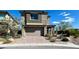 Beautiful two-story home showcasing a neutral color, complemented by a brick driveway and well-manicured landscaping at 438 Wind Poppy St, Las Vegas, NV 89138