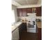 A kitchen features a white oven, dark cabinets and light counter tops at 4770 Topaz St # 79, Las Vegas, NV 89121